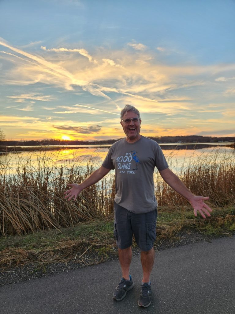 Me, standing in front of a lake, wearing shorts and short sleeves, in November, in Minnesota.